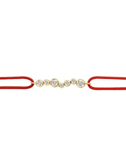 The looped cord bracelet featuring a sliding knot tie, meets circular diamond drops, encased in 18k recycled solid gold.