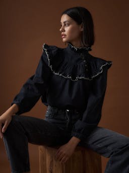 Perfect Seventy + Mochi fall blouse. Sustainable washed black denim with hand-stitched details. Featuring a high-neckline and statement shoulder shape. Collagerie.com